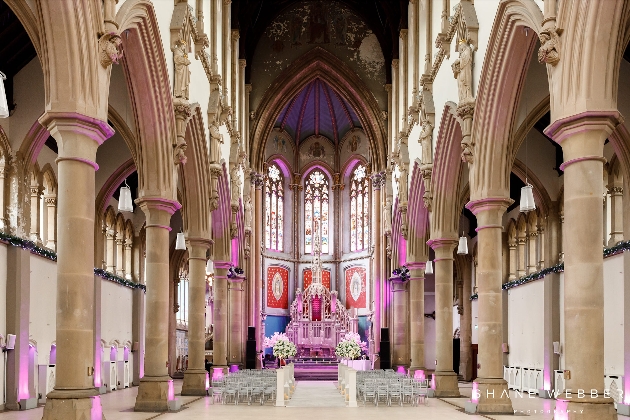 A large chapel decorated with columns, chairs and flowers