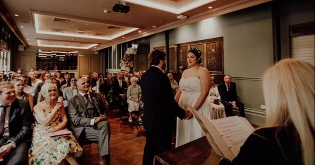 A bride and groom getting married in front of their friends and family