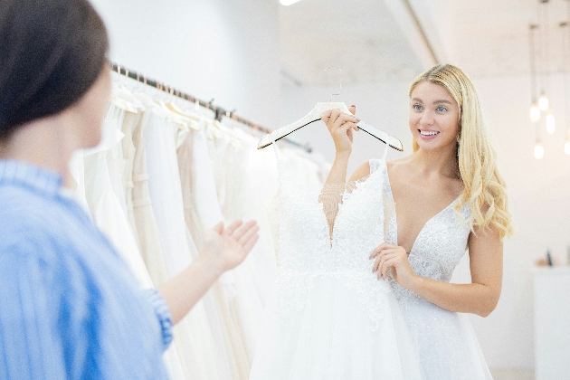 A woman showing another woman a wedding dress