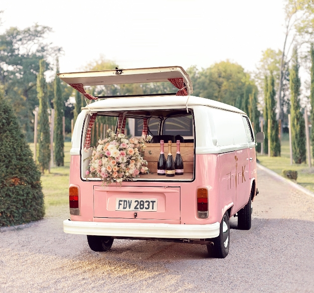 The back of a pink Campercan filled with flowers and bottles of drink