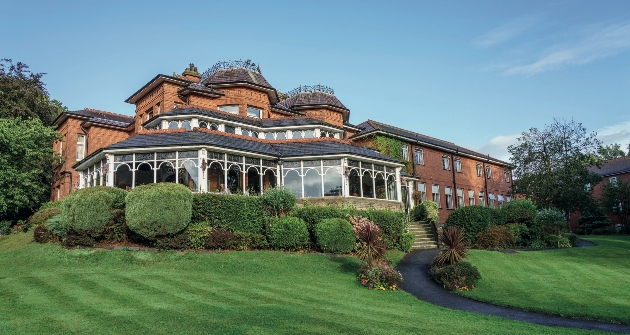 The exterior of a large red brick building with a conservatory