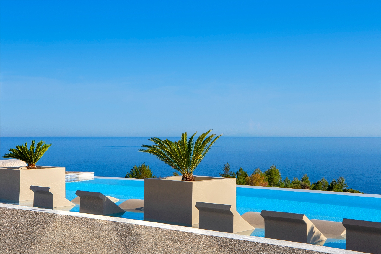 pool looking out to see white stone chairs nestled in to water