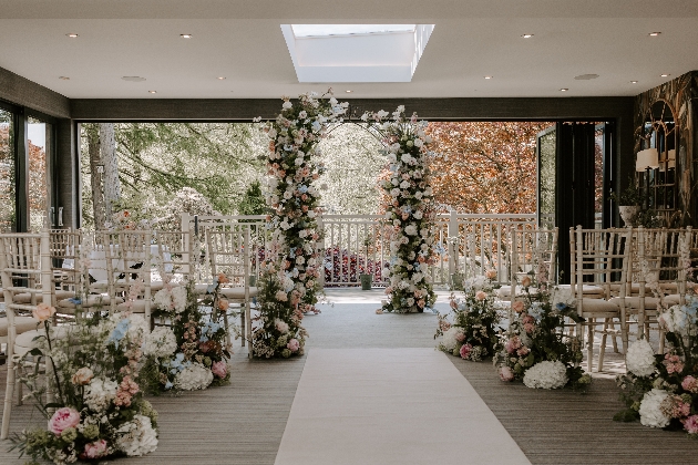 A light-filled room decorated with flowers and chairs