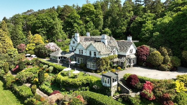 A white building surrounded by trees and flowers