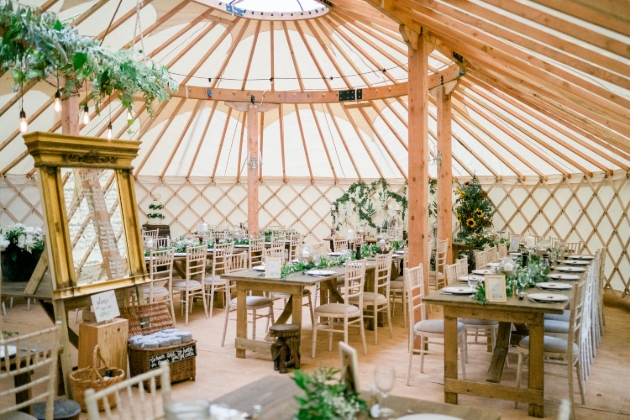 The inside of a yurt decorated with tables and chairs